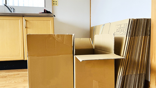 部屋に用意された、不用品回収用の段ボール箱と折りたたまれた大量の段ボール