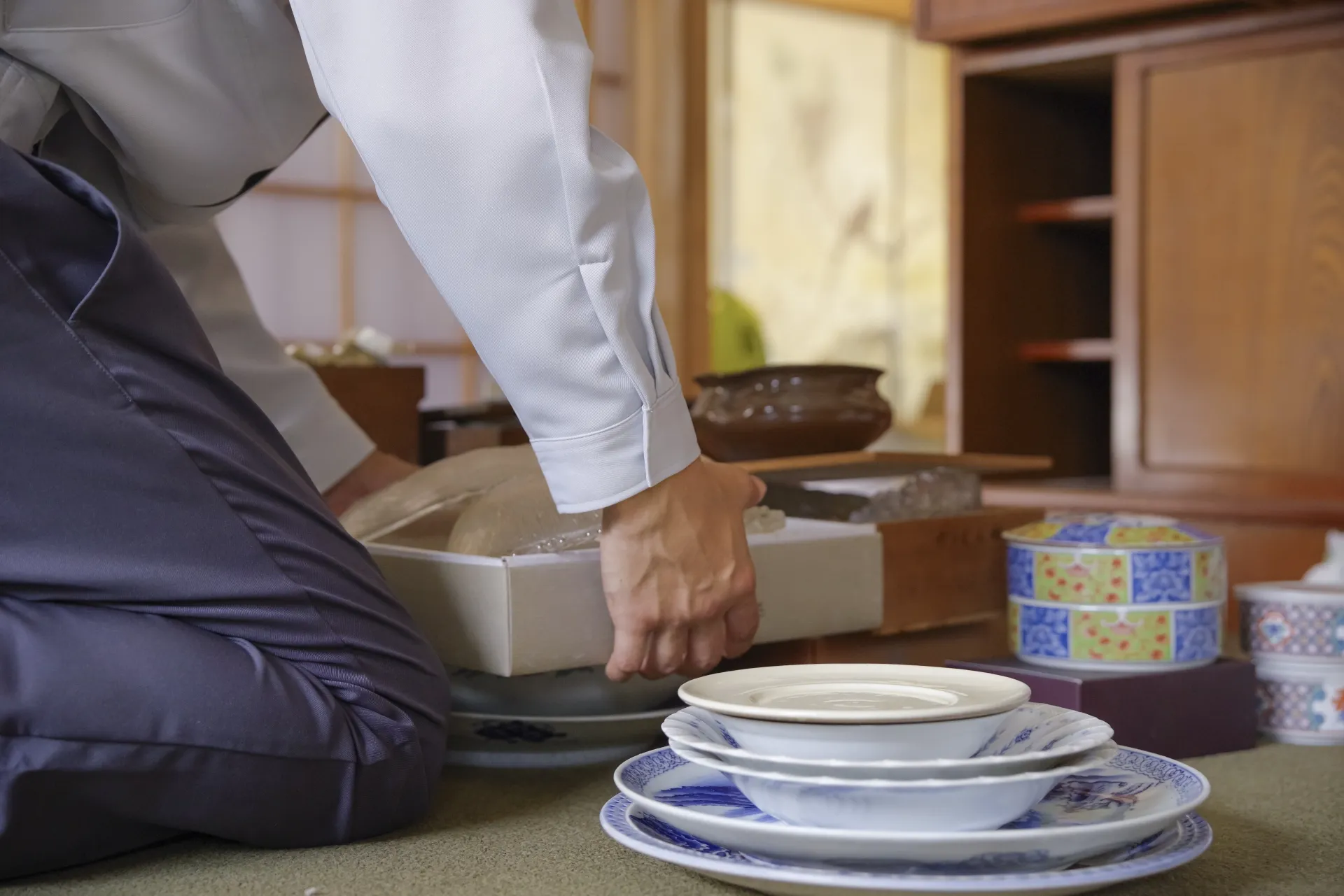 長年大切に使ってきた食器や工芸品を、リユースに出すために丁寧に箱詰めしている様子